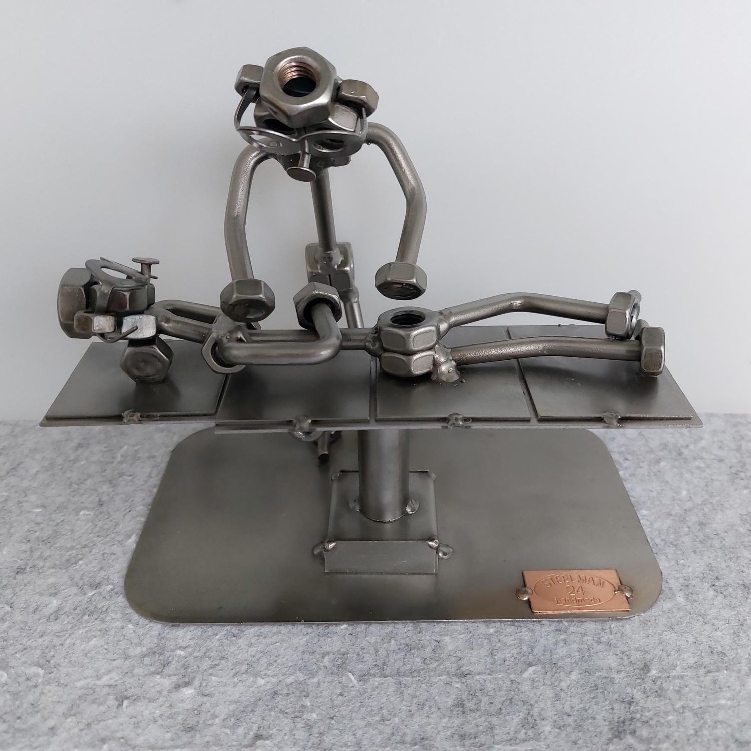 Metallfiguren bei dem ein Mensch eine osteopatische Behandlung hat.